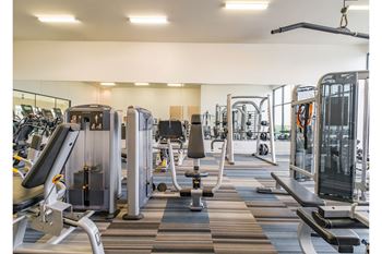 fitness center with cardio machines and weights at Reveal Skyline apartments